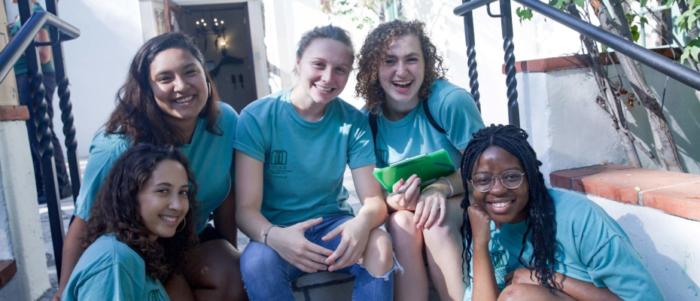 five scripps students smiling and sitting on staircase